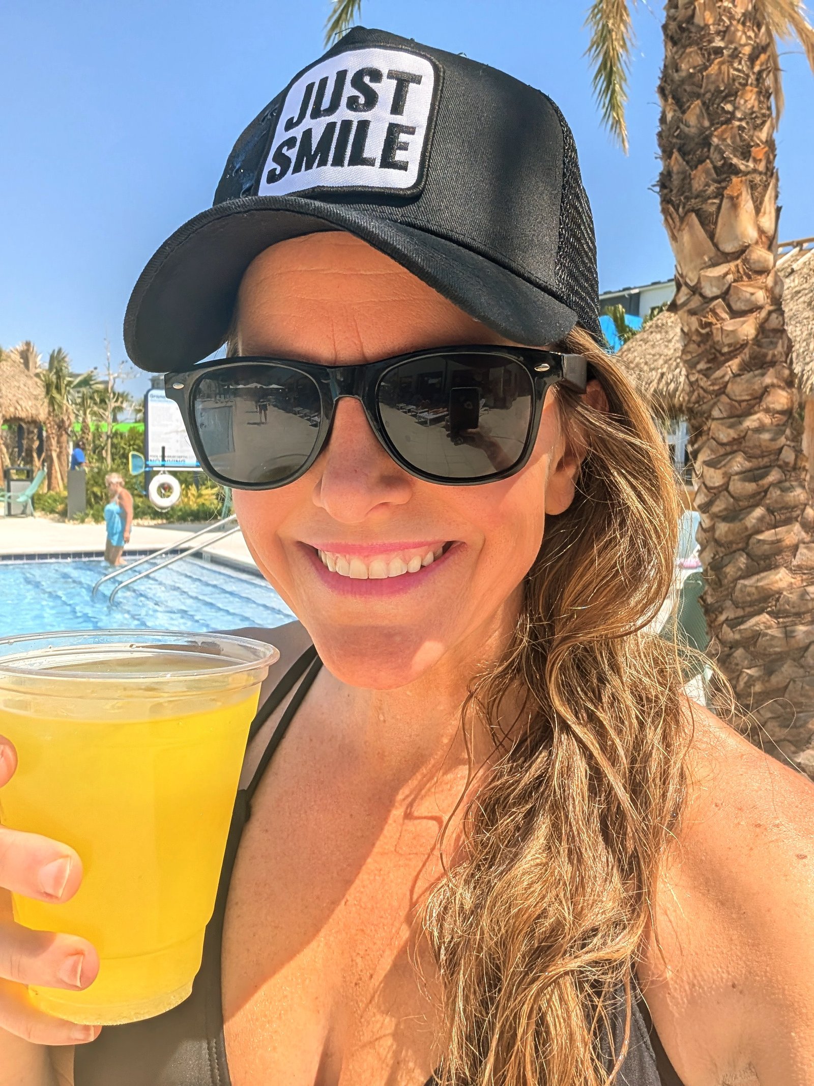Maria Williams — Author of The Pretty Truth Maria Williams smiling at the beach with a drink in hand — author of The Pretty Truth book